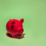 Red piggy bank on a green background symbolizing savings and financial planning.